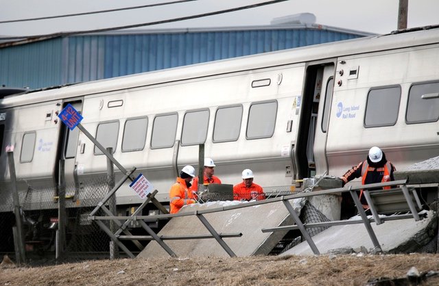Emergency personnel look over the site of a fatal train collision in Westbury, N.Y.