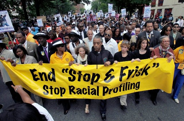 The Rev. Al Sharpton, center, walks with demonstrators during a silent march to end New York's "stop-and-frisk" program in 2012.
