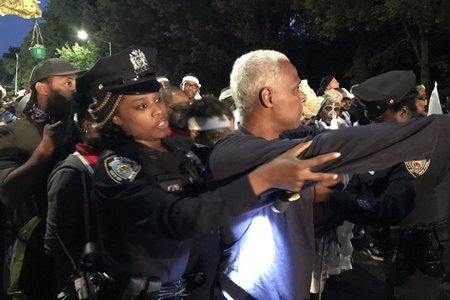 A police officer screens a person at J'Ouvert, September 4, 2017