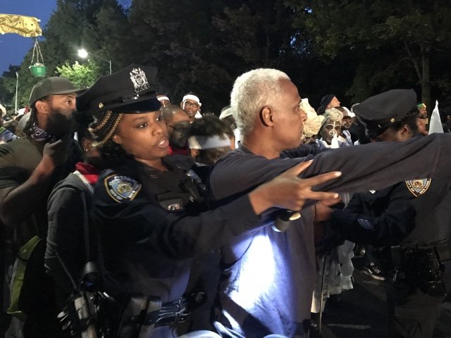 A police officer screens a person at J'Ouvert, September 4, 2017