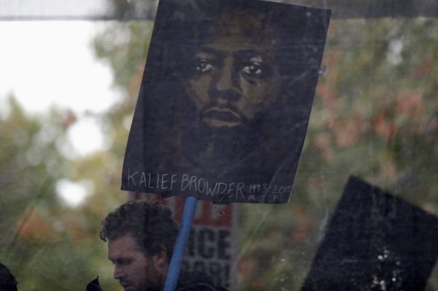A protester holds a picture Kalief Browder, who spent three of his late teen years imprisoned on Rikers Island waiting to be tried for a petty robbery charge that was ultimately dismissed.