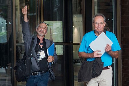 New York Daily News staff photographers Todd Maisel, left, and Andrew Savulich walk out of the newspaper's office after being laid off, in New York