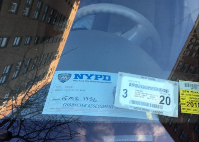 A vehicle displaying an NYPD placard from the "Character Assessment Unit" blocks the bus lane on Second Avenue