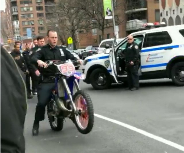 An NYPD officer rides a dirt bike in Harlem