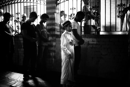 Boy Praying During Ramadan on the Street outside the Mosque Because the Mosque is Full, Parkchester Jame Masjid, Bronx, NY, 2012. (Robert Gerhardt/MCNY)