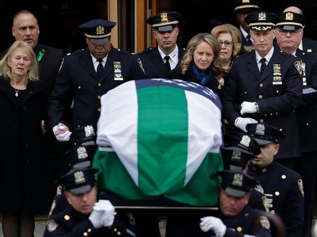 Leanne Simonsen, the widow of Det. Brian Simonsen, follows his casket from the Church of St. Rosalie in Hampton Bays, N.Y.